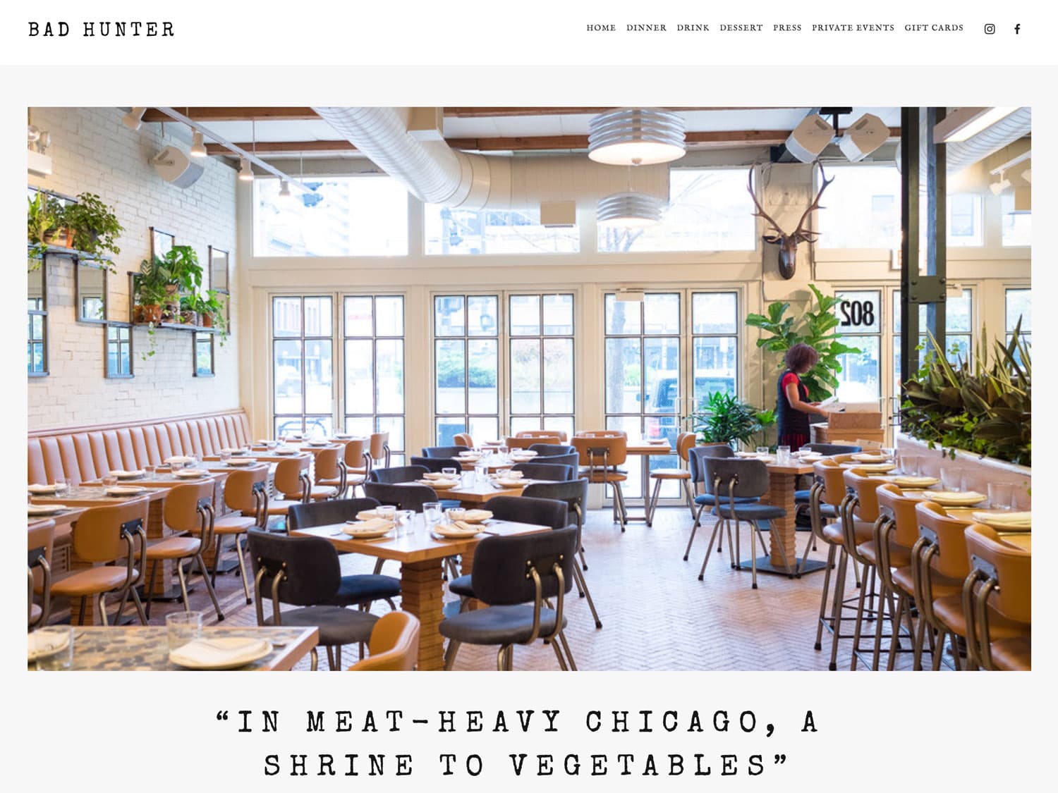 A screenshot of a website for a modern, casual upscale restaurant shows a brightly-lit dining room with an airy vibe, plants on the walls throughout and modern wooden tables and chairs with tasteful place settings seen throughout